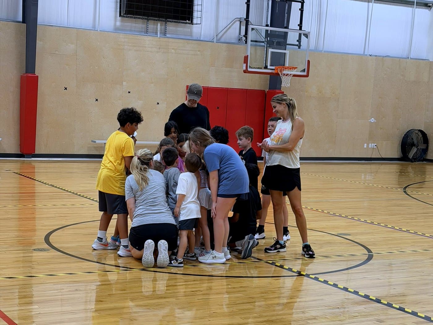 An ATX Wildcats team huddled together with their coaches